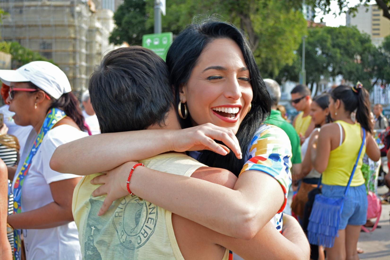 Alejandra Oraa hugging a passer-by at Praça XV, in Rio de Janeiro