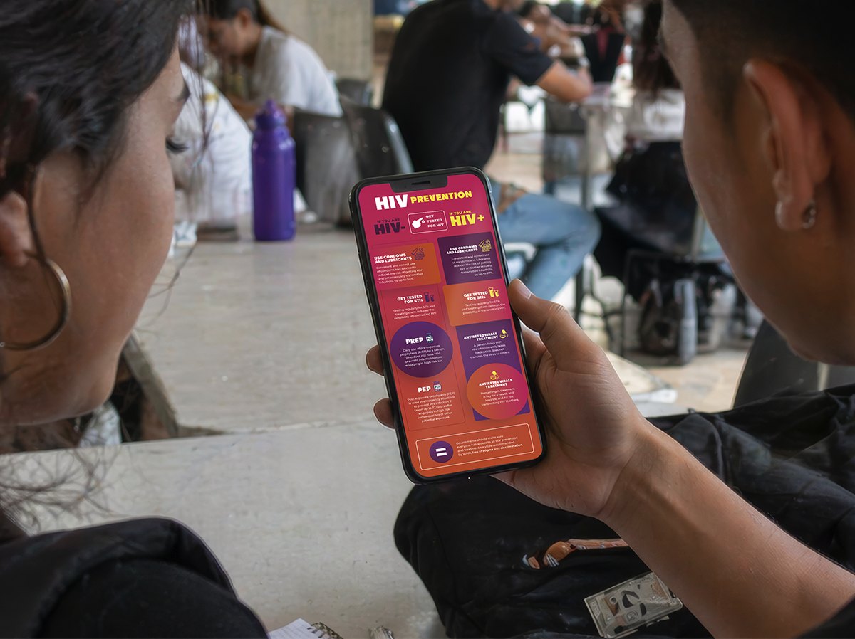 Two young people reading the HIV prevention guide on a phone