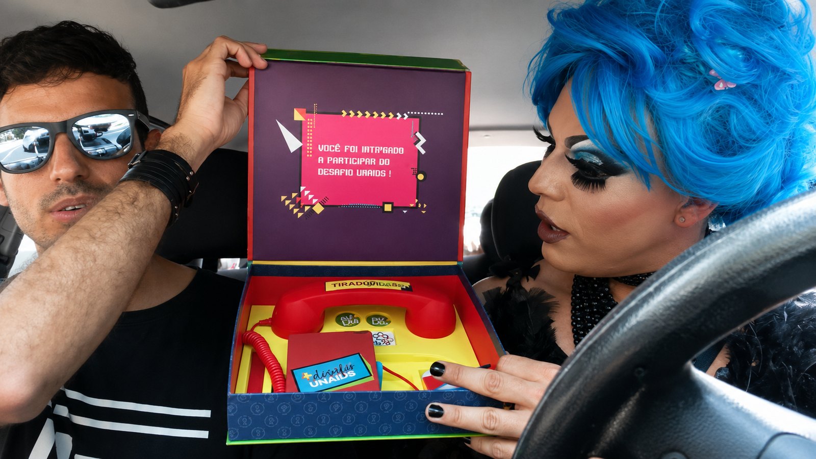 Creators opening the Desafio UNAIDS box in a car